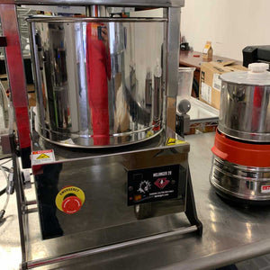 Commercial chocolate melanger machine used in bean-to-bar chocolate making at Encore Coffee & Chocolate, refining cacao into smooth, artisan chocolate.
