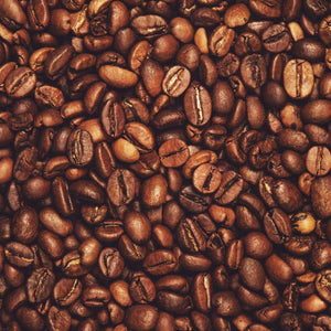 Flat lay of freshly roasted specialty coffee beans with rich brown tones, highlighting artisan coffee quality and flavor depth.