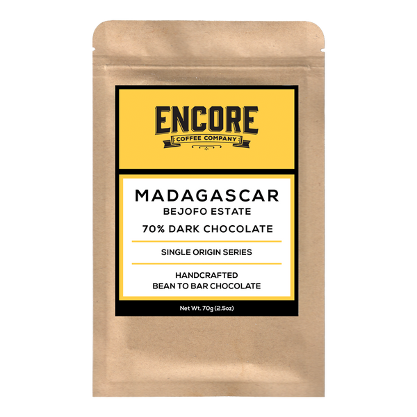 Image of Encore Coffee's 70% Dark Madagascar chocolate bar. The chocolate is shown unwrapped with the bar's texture visible. The packaging is visible in the background with the Encore Coffee logo prominently displayed.