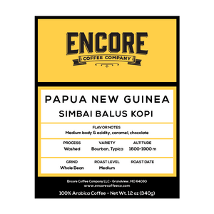 A yellow background with the Encore label featuring the words "Papua New Guinea - Simbai Balus Kopi" in bold font. Below the title is a description of the coffee, and at the bottom are the weight measurements.